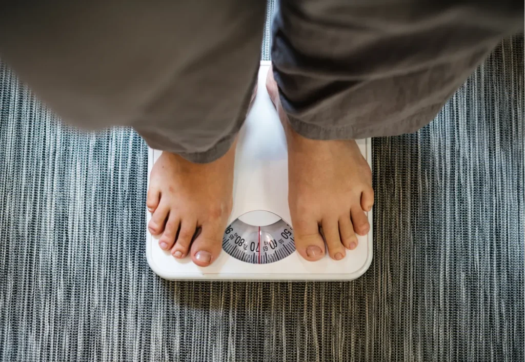 a person checking body weight on the machine