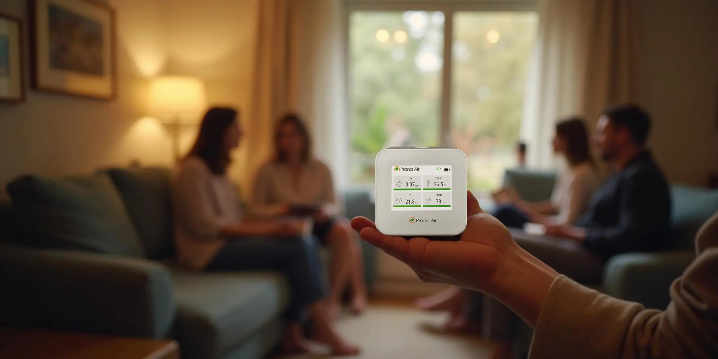 OxyCo monitor inside a room with people sitting on a sofa
